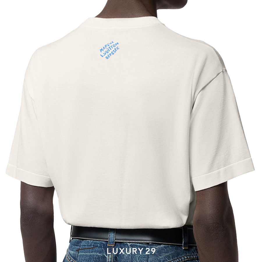 Person wearing a beige t-shirt with a logo on the back, standing against a white background.