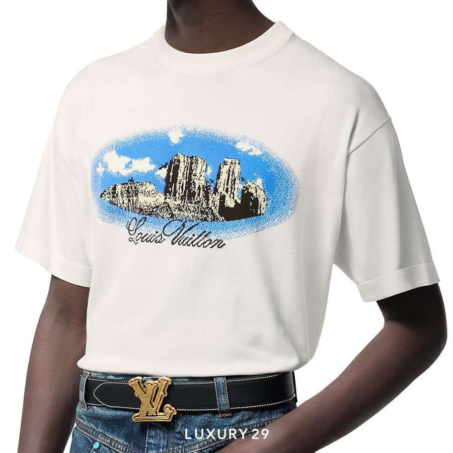 Person wearing a white t-shirt with a graphic design and a Louis Vuitton belt.